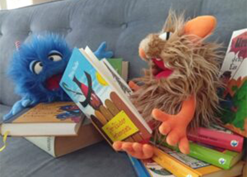 Verschiedene Kinderbücher und zwei Bauchrednerpuppen
