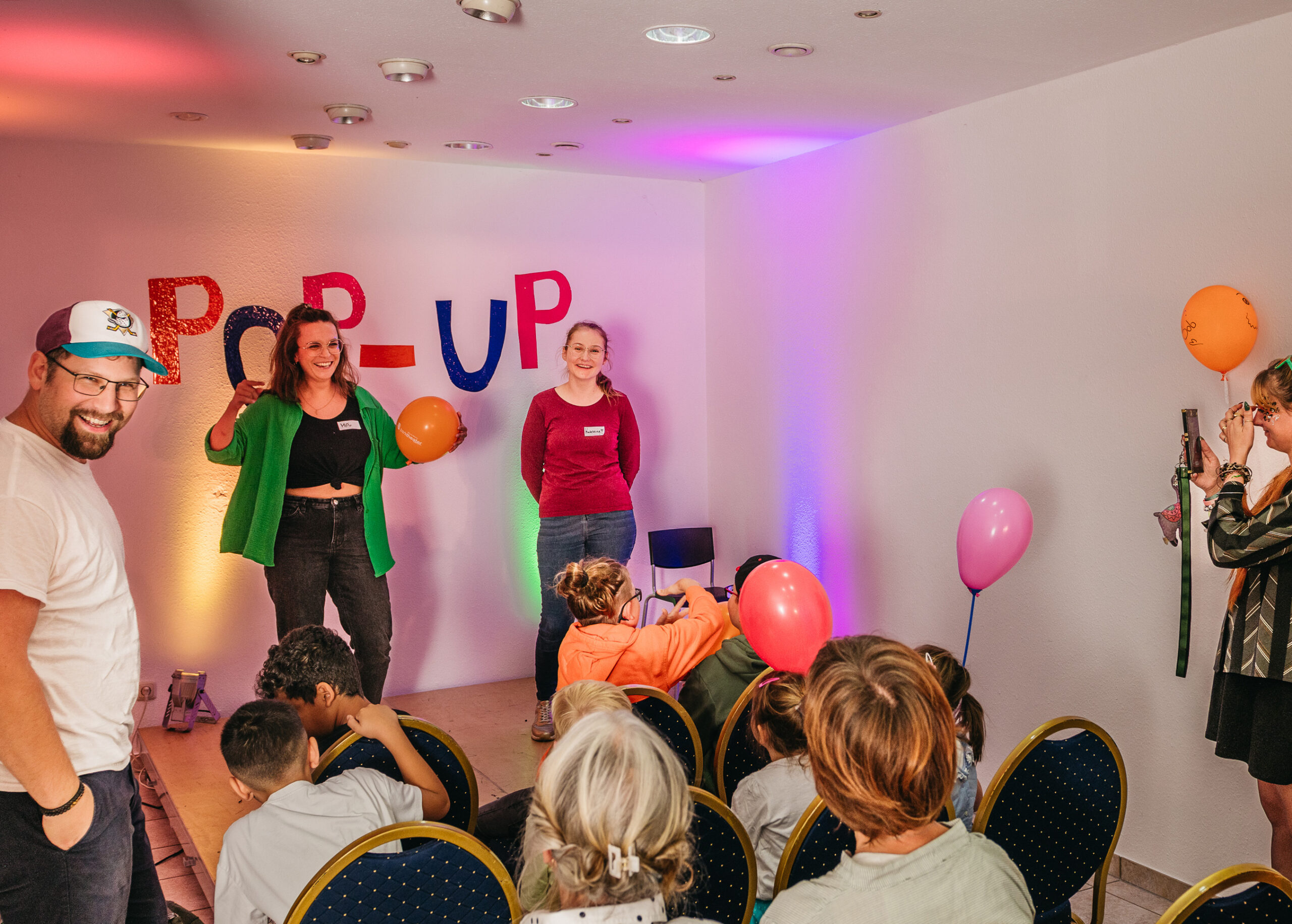 Das Bild zeigt die Kulturvermittlerin Miriam Engelmann in Aktion mit jungen Talenten auf der kleinen Bühne des Pop-Up Theaters.