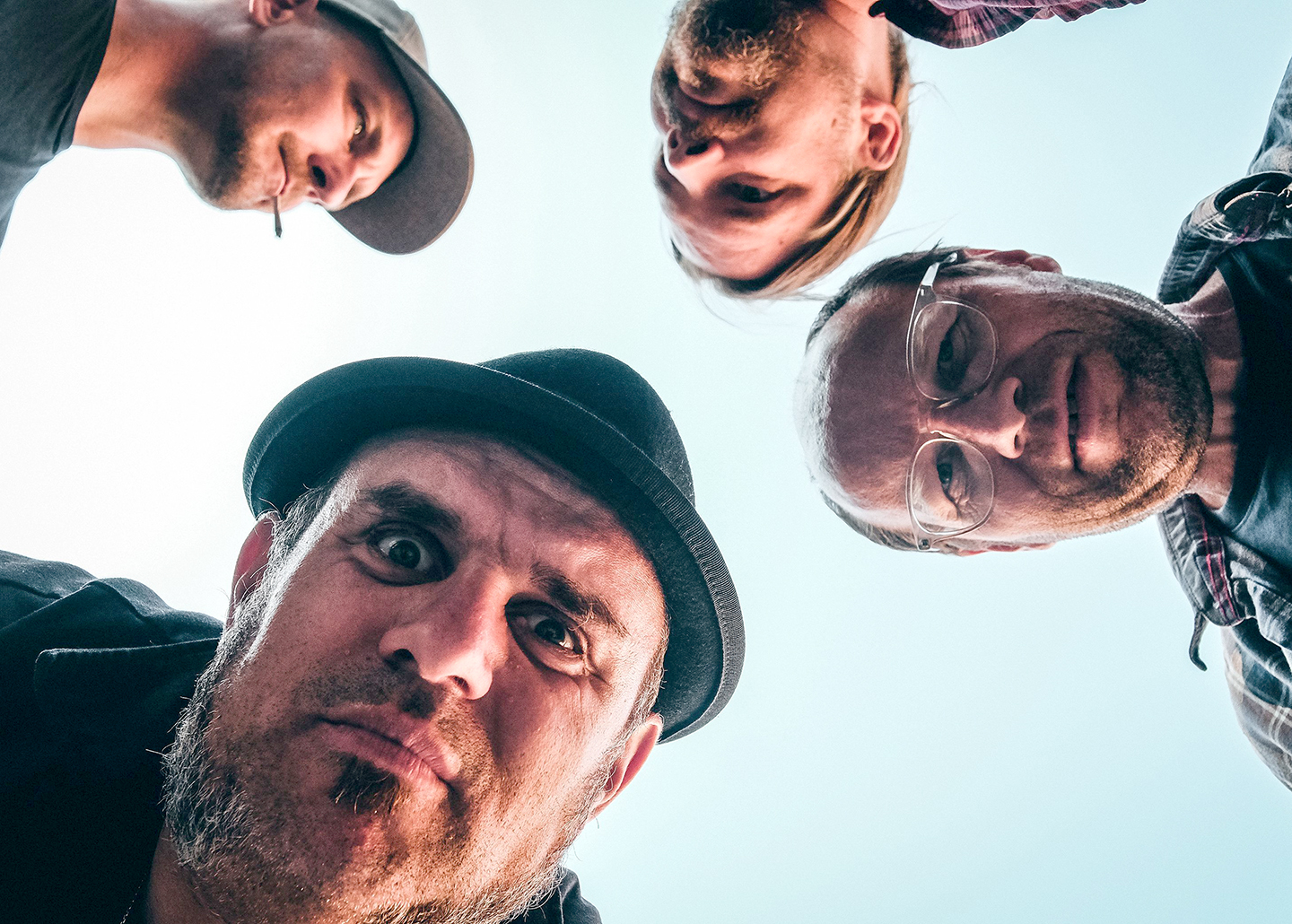 Vier Bandmitglieder von Pils & Kippe schauen von oben in die Kamera.