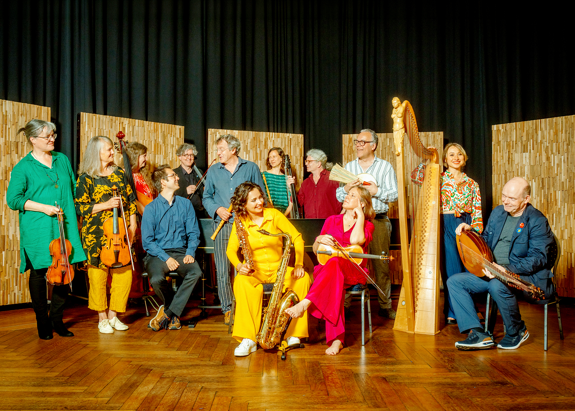 Auf dem Bild sind die im ABBA-Look gekleideten Musikerinnen und Musiker der Lauten Compagney mit ihren Instrumenten zu sehen.