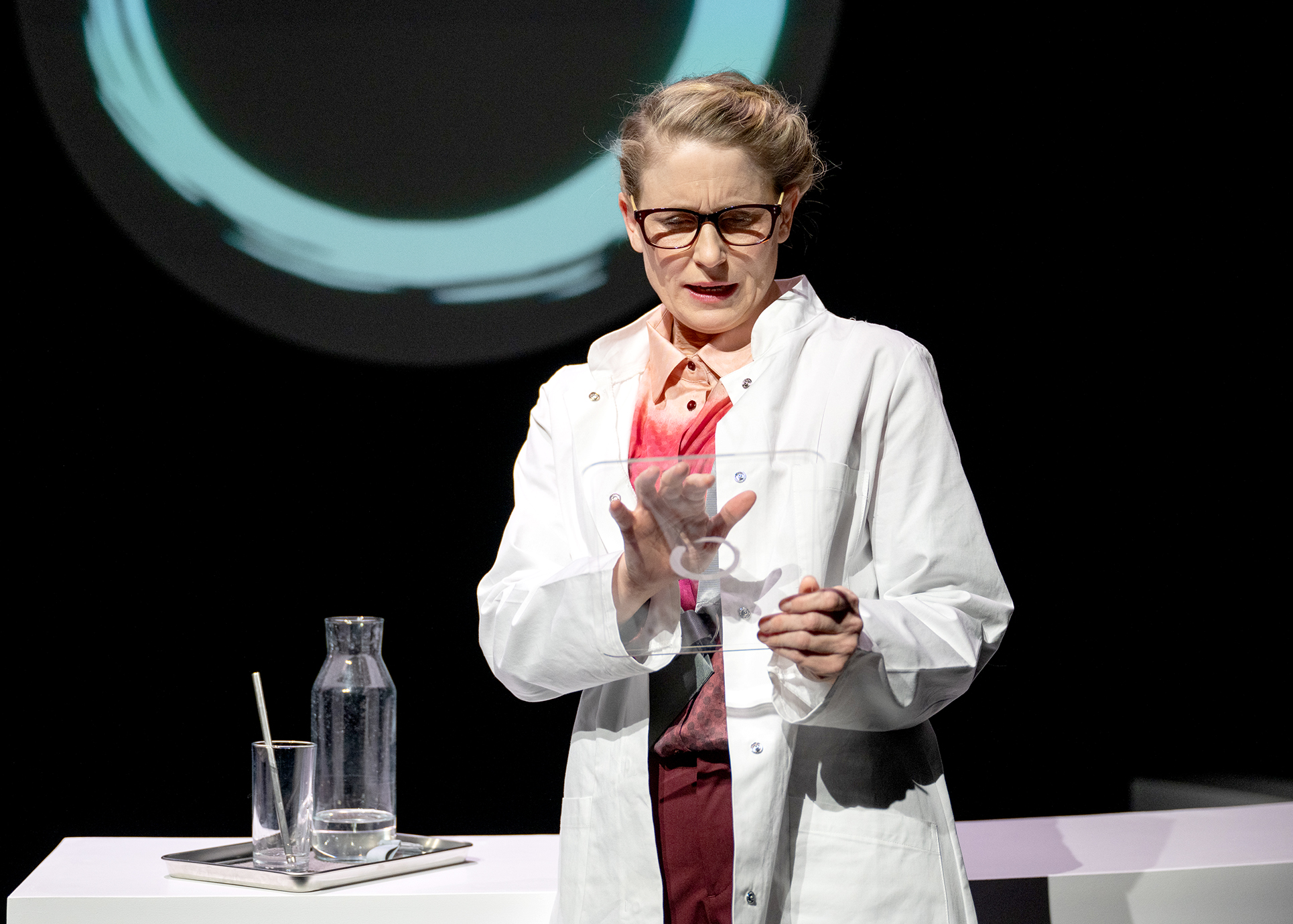 Eine Dame in weissem Kittel steht vor einem Labortisch