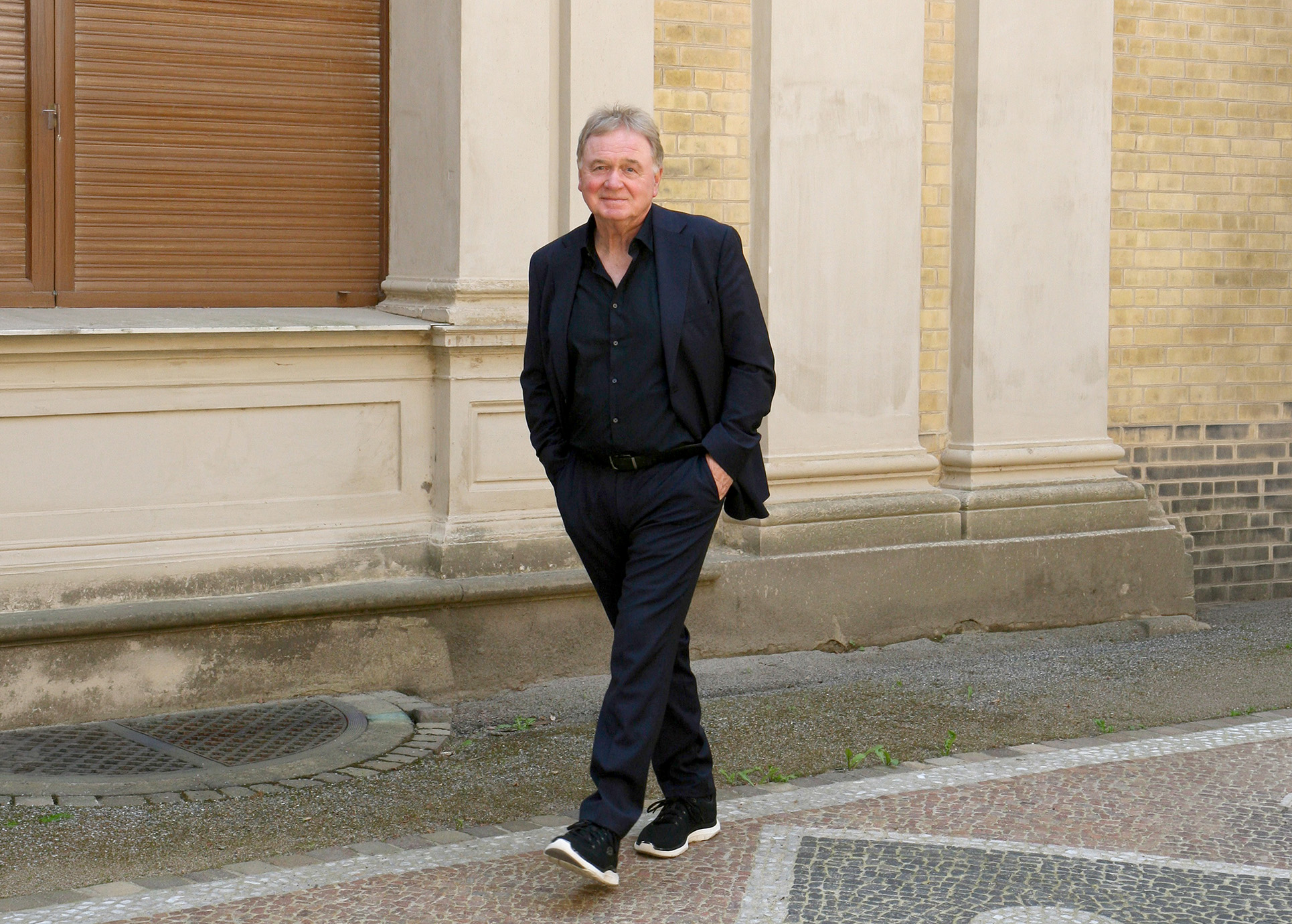 Klaus Hoffmann spaziert eine Straße entlang