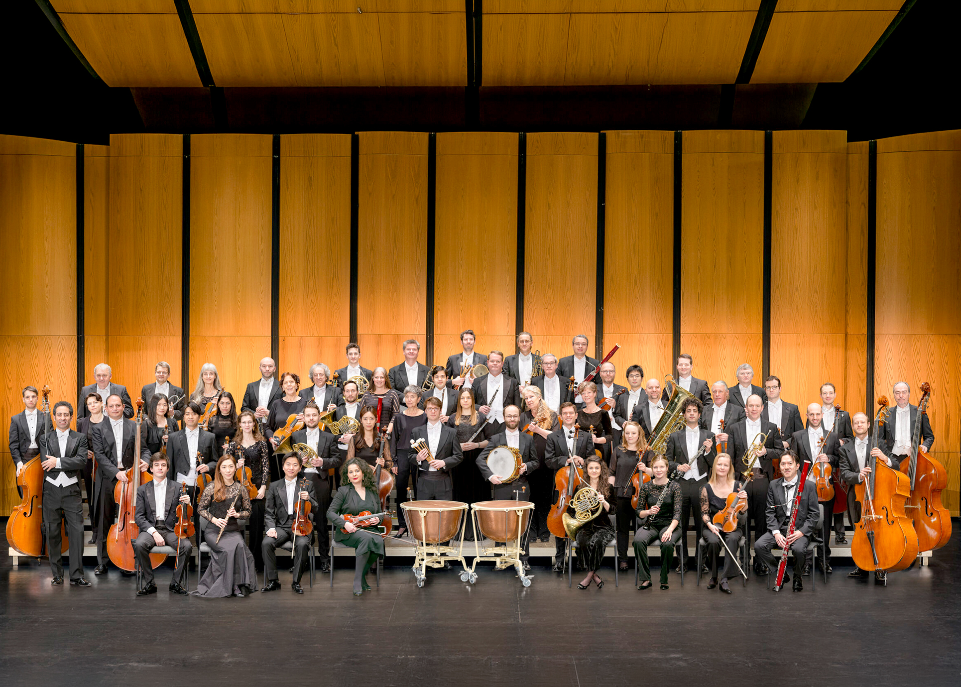 Die Mitglieder des Orchesterns stehen gemeinsam mit ihren Instrumenten auf der Bühne