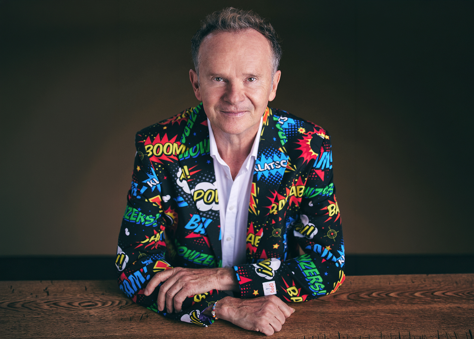 Willy Astor in knallbuntem Sakko schaut lächelnd in die Kamera