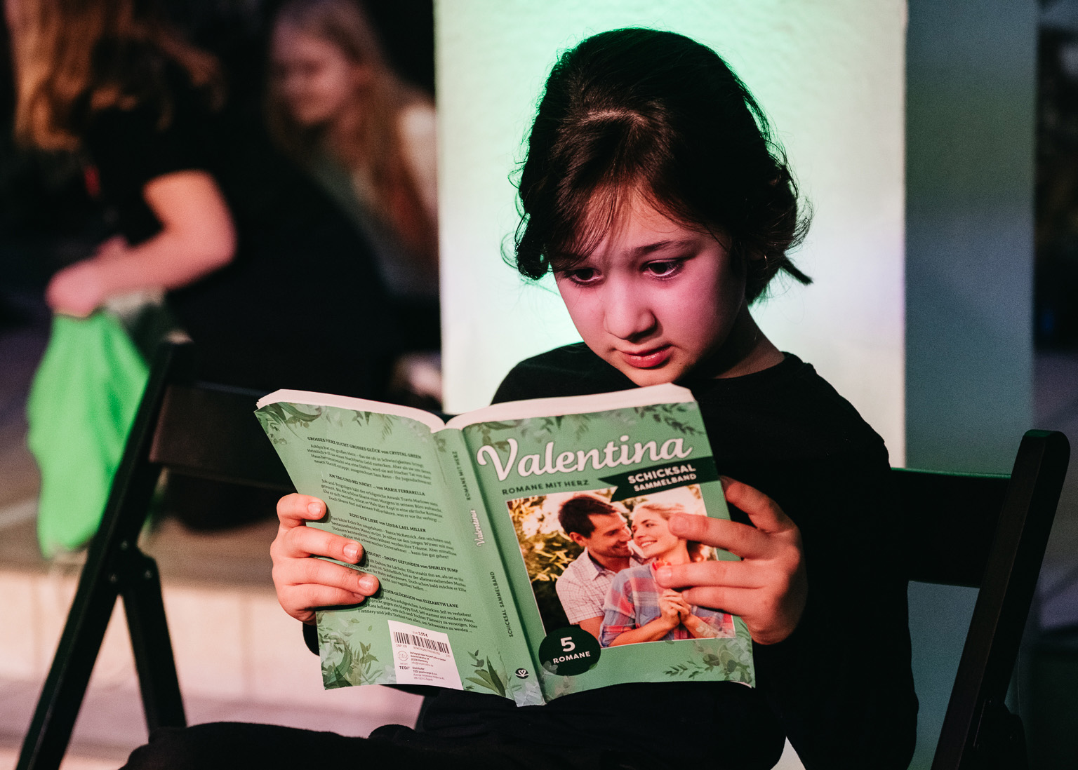 Eine Teilnehmerin aus einem Theater-Projekt liest in einer Zeitschrift.
